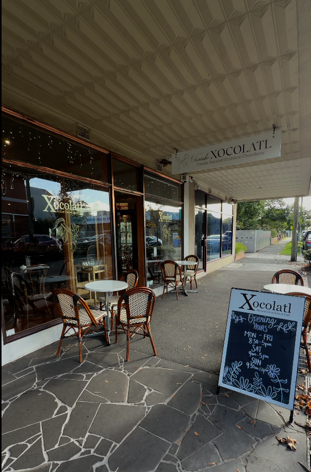 Outdoor seating and the chalkboard opening-hours sign outside the Torode Xocolatl chocolate shop and cafe